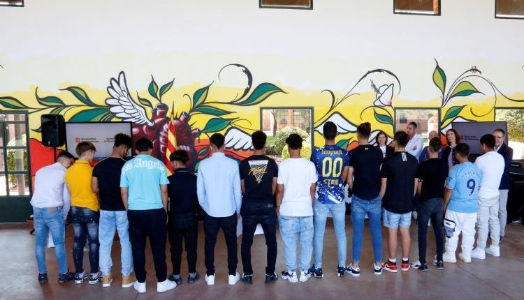 Joves del centre de justícia juvenil El Segre de Lleida pinten un dels murs de l'edifici en un projecte d'art comunitari